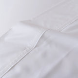 A close-up of the Linenly Bamboo Fitted Sheet - White, neatly folded to showcase its visible stitching, smooth fabric texture, and luxurious softness.